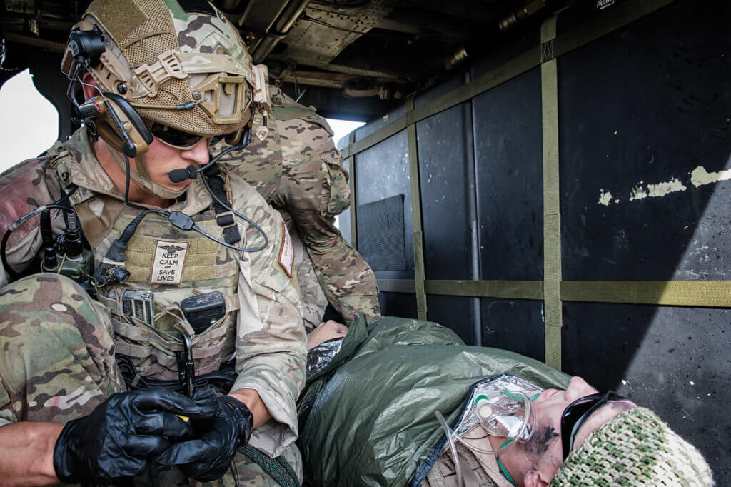 A 57th RQS pararescueman works on a simulated casualty in the back of a HH-60G Pave Hawk.