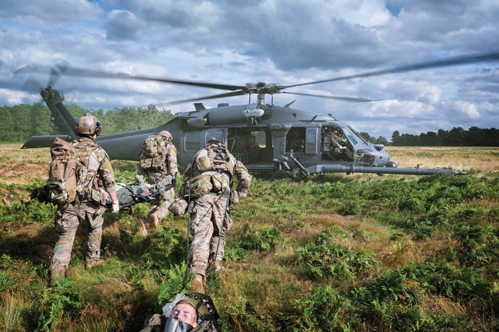 57th Rescue Squadron pararescuemen carry and drag simulated casualties towards the waiting 56th Rescue Squadron HH-60G Pave Hawk.