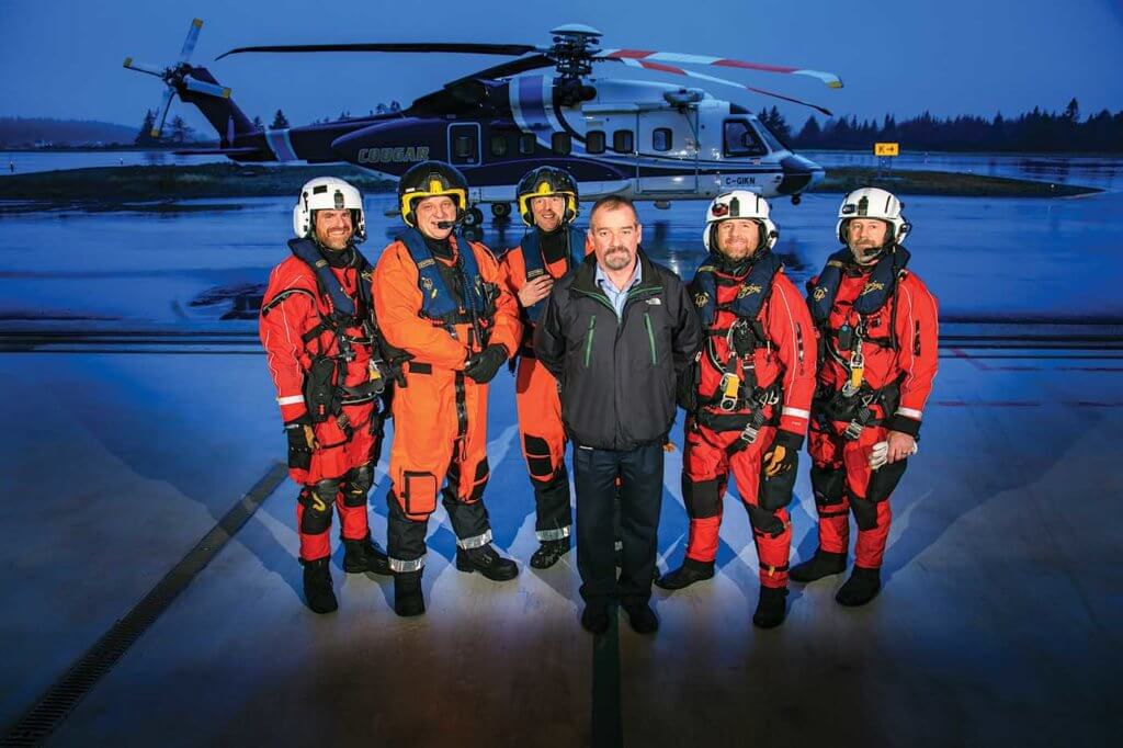 Rick Banks, Cougar's search-and-rescue program manager, stands in front of a SAR crew in the company's custom-built search and rescue hangar in St. John's. Heath Moffatt Photo