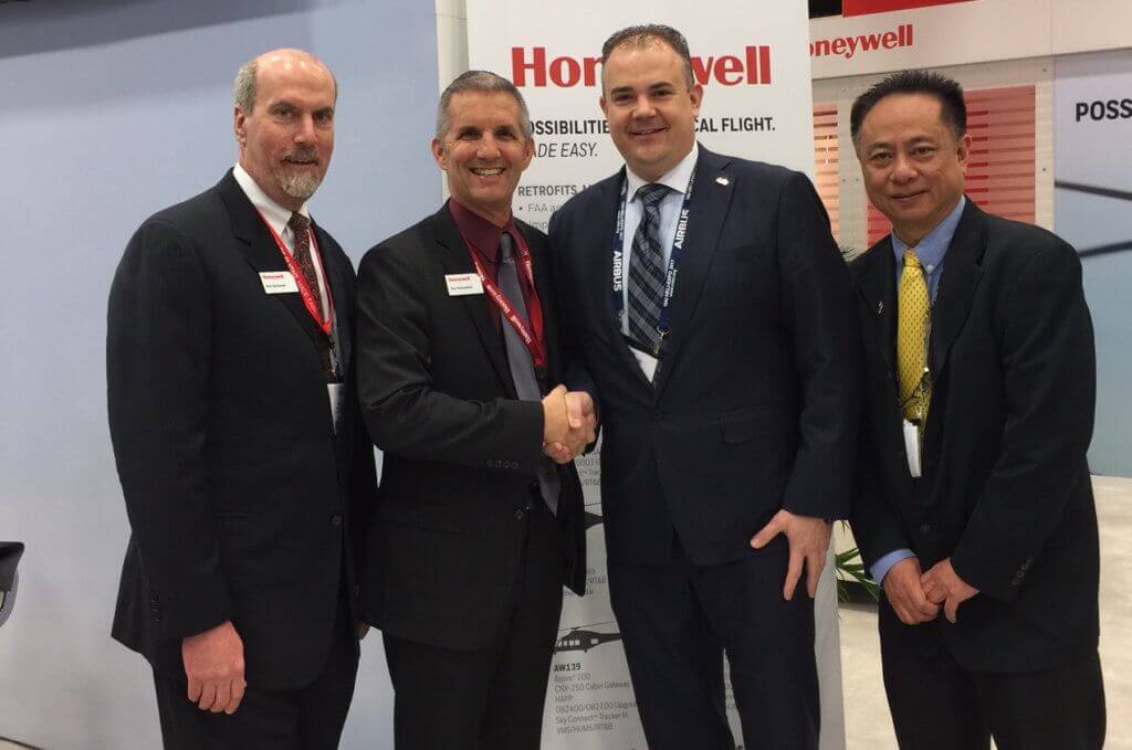Four men stand at agreement signing ceremony