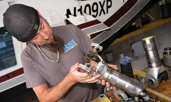 An AW109 rotorhead part is inspected before it is reinstalled.
