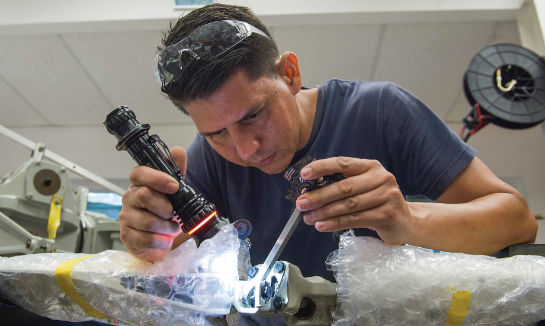 Julio Cancel performs a visual inspection of a Bell 407 tail rotor.