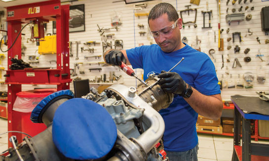 Nestor Lopez reinstalls the cases on a Rolls-Royce M250 engine compressor.