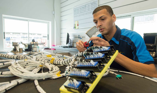 In the wire harness shop, Jonathan Ferrer tests a completed harness assembly for CASA 212.