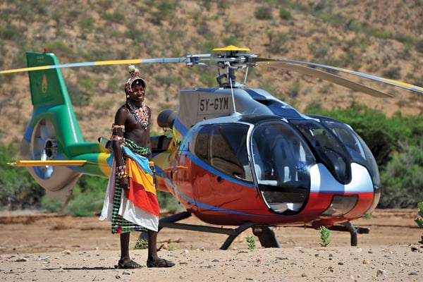 A Samburu warrior poses briefly in front of an equally colorful EC130. The author traveled to virtually every corner of Kenya during his time with Nairobi-based Lady Lori Helicopters.