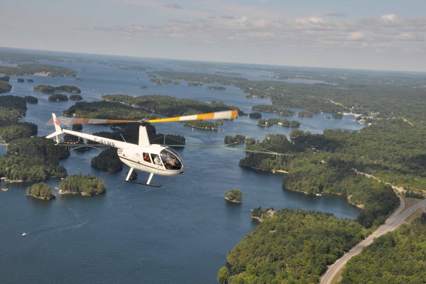 A Kouri's Kopters Robinson R44 flies tourists over the 1000 Islands bridge which spans the St. Lawrence River between Ontario and New York state.