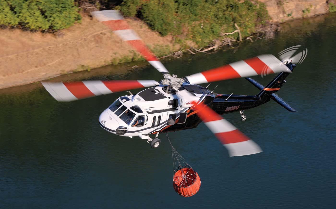 A PJ Helicopters Sikorsky UH-60 Black Hawk prepares to collect water during a firefighting operation. The company is one of several to take advantage of the recent availability of Black Hawks in the civilian marketplace.
