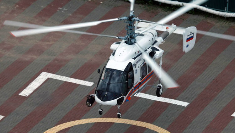 Ka-226T helicopter flying over helipad.