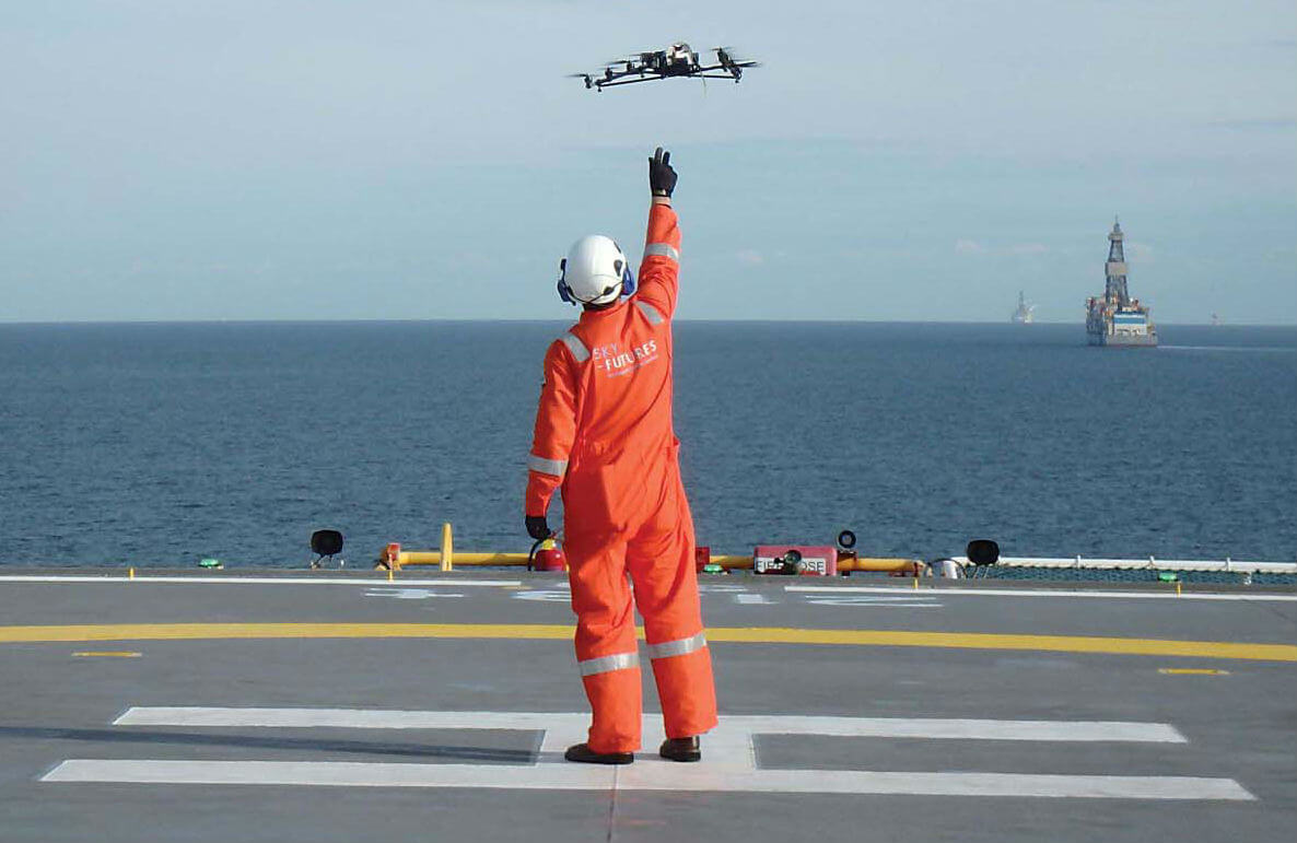 A Sky-Futures unmanned aerial vehicle (UAV) deployment team member releases an aircraft off the helipad of an offshore platform. The company uses a variety of UAVs for different work, but its current offshore UAV is the AscTec Falcon 8. Sky-Futures Photo