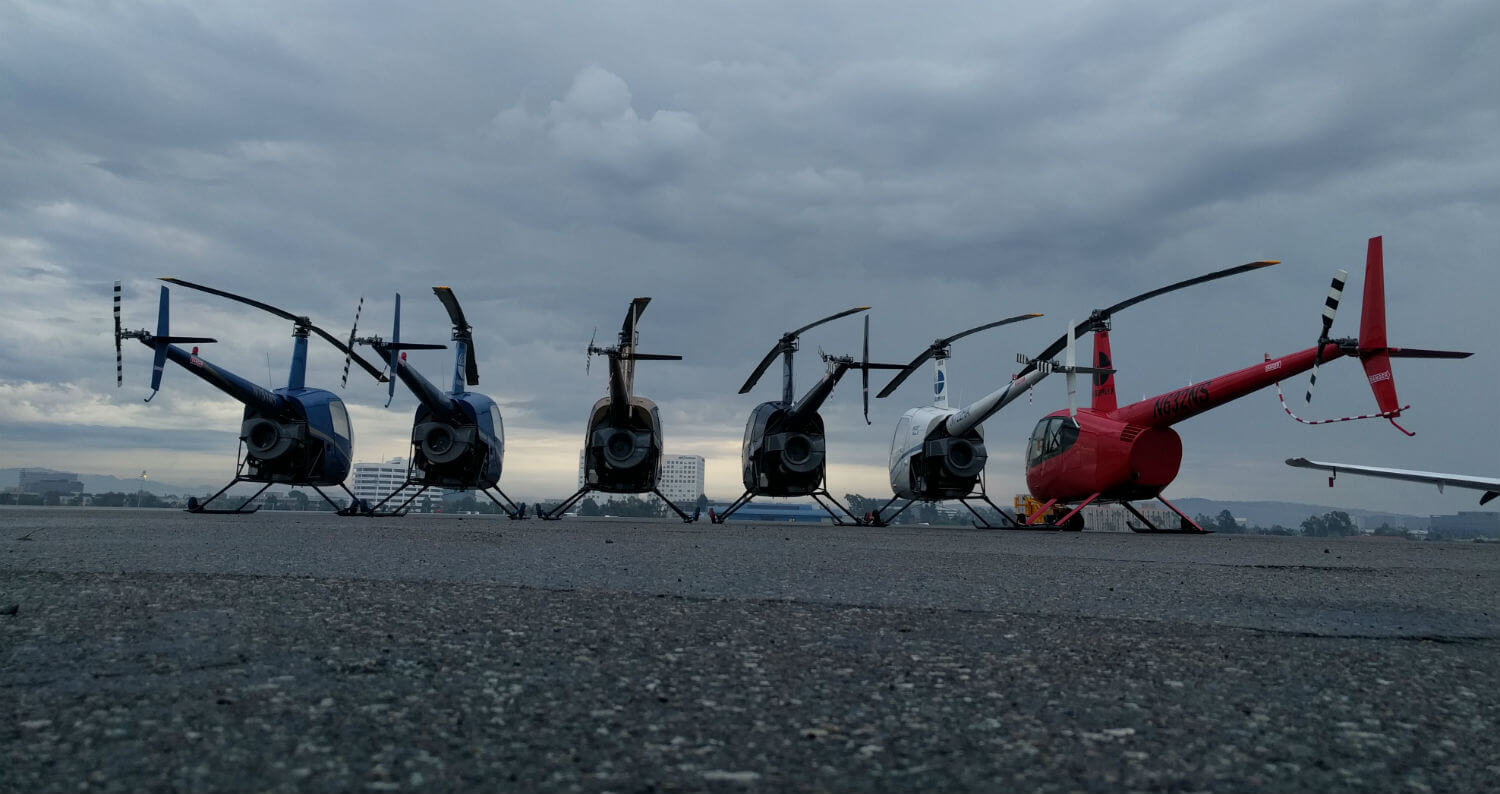 Robinson helicopters sit on the ramp.