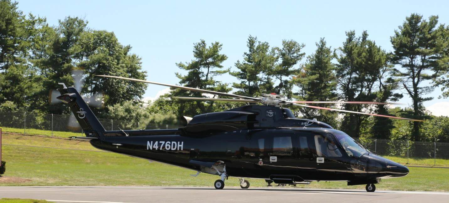 A Sikorsky S-76 sits on a helipad.
