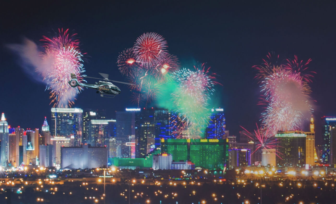 Helicopter flies through cityscape with fireworks exploding around it.