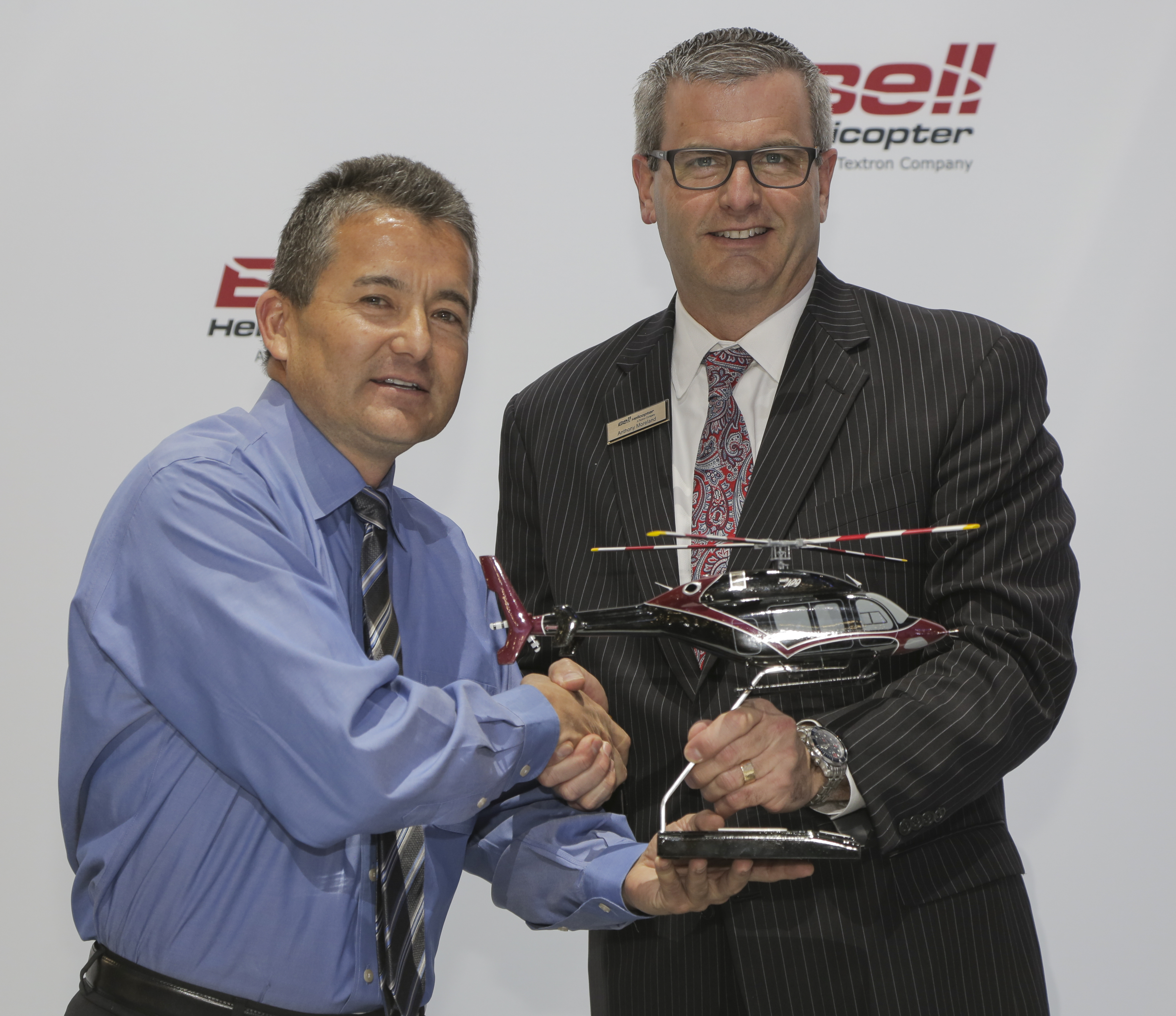 Terry Miyauchi from Arizona Department of Public Safety, left, and Bell Helicopter’s Anthony Moreland, shake hands.