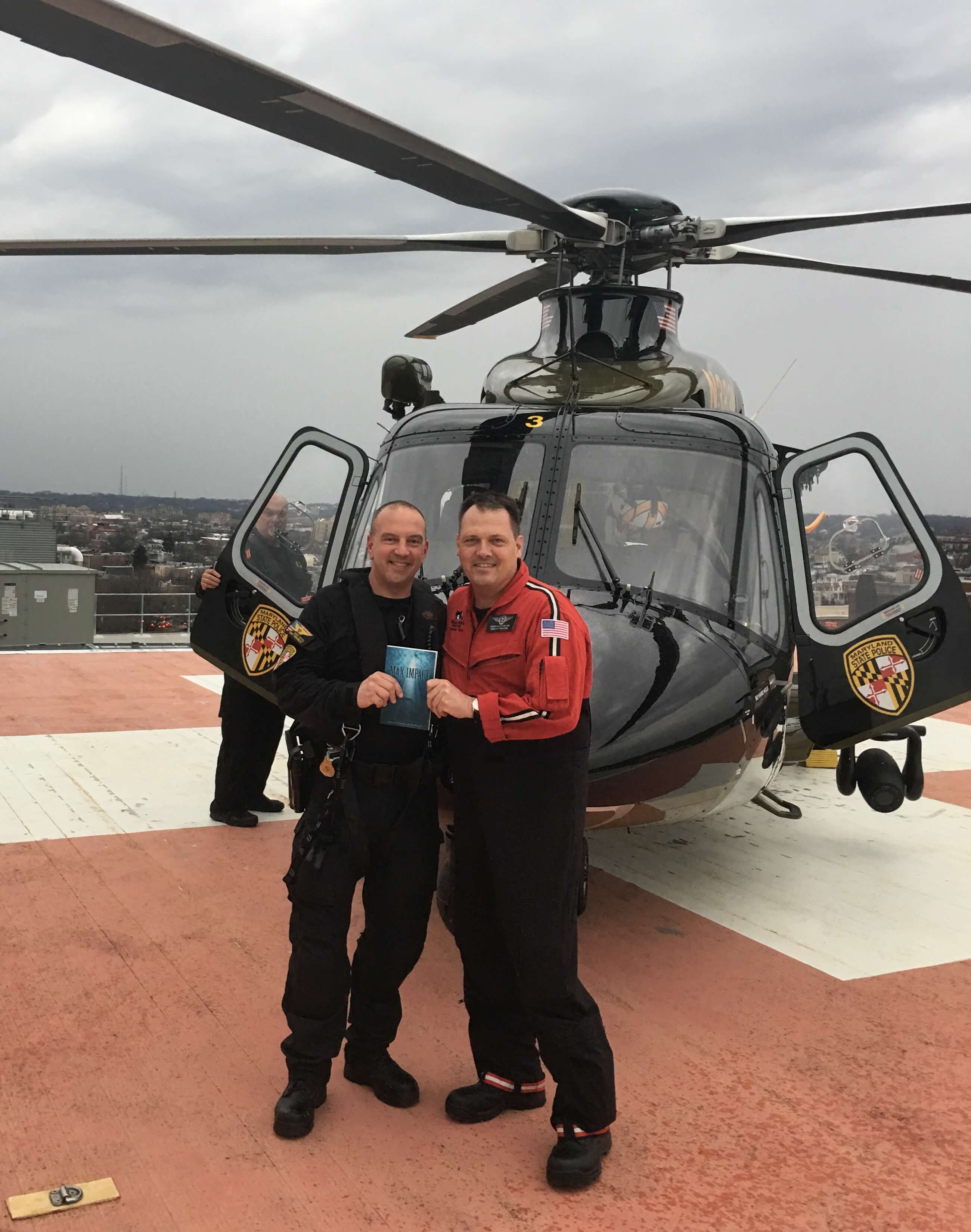 Dave Svites, left, was on the Maryland State Police helicopter Trooper 2 the night of Jonathan Godfrey’s rescue. He recently visited Godfrey at work to receive a signed copy of Max Impact. Photo courtesy of Jonathan Godfrey
