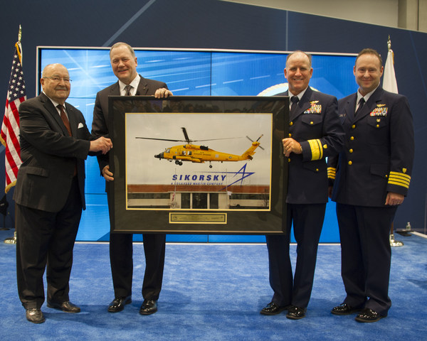 Sergei Sikorsky, left, and Sikorsky president Dan Schultz present U.S. Coast Guard aviators Rear Adm David Callahan and Capt Joe Kimball with a framed photo of an MH-60T Jayhawk helicopter taking off from Sikorsky's Stratford, Connecticut, headquarters on Dec. 7, 2016. The aircraft is painted chrome yellow to commemorate the U.S. Coast Guard's aviation centennial