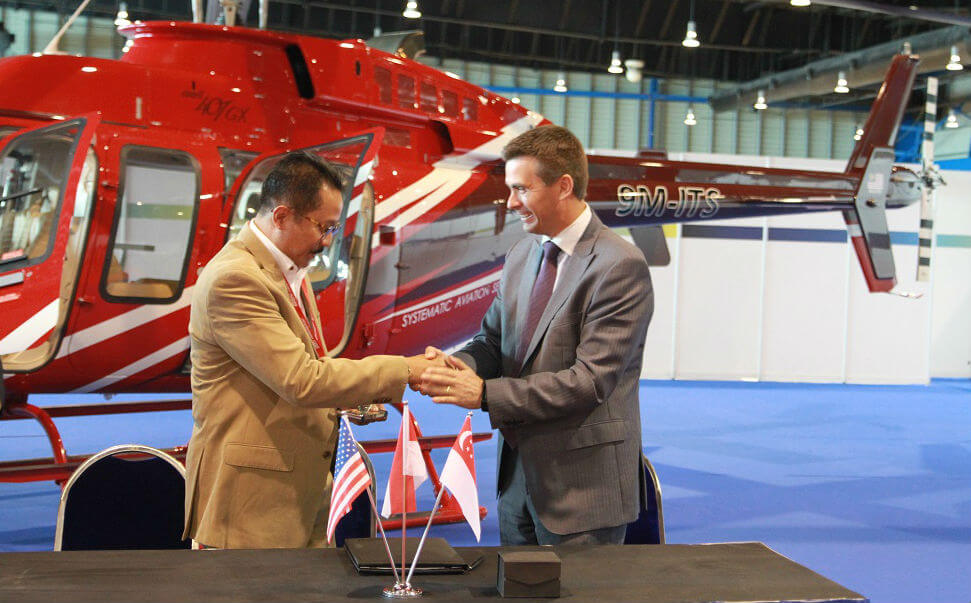 Capt Heru Susatyo, Air Pacific Utama, and Patrick Moulay, executive vice president, global commercial sales and marketing, celebrate the recent signing at Rotorcraft Asia. Bell Photo