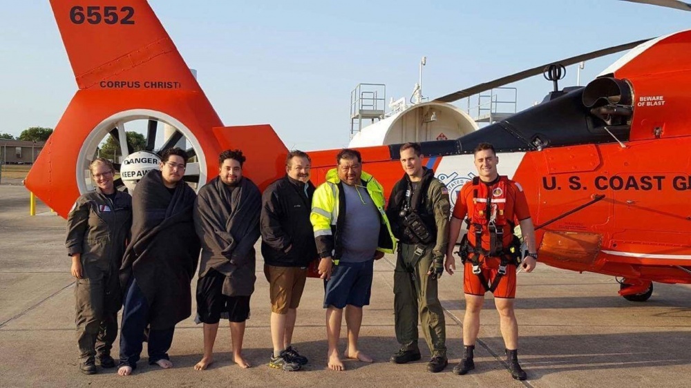 Coast Guard aircrew members take a photo with four people whose vessel capsized 15 miles north of Port Mansfield, Texas, Sunday morning on Apr. 30, 2017. U.S. Coast Guard Photo