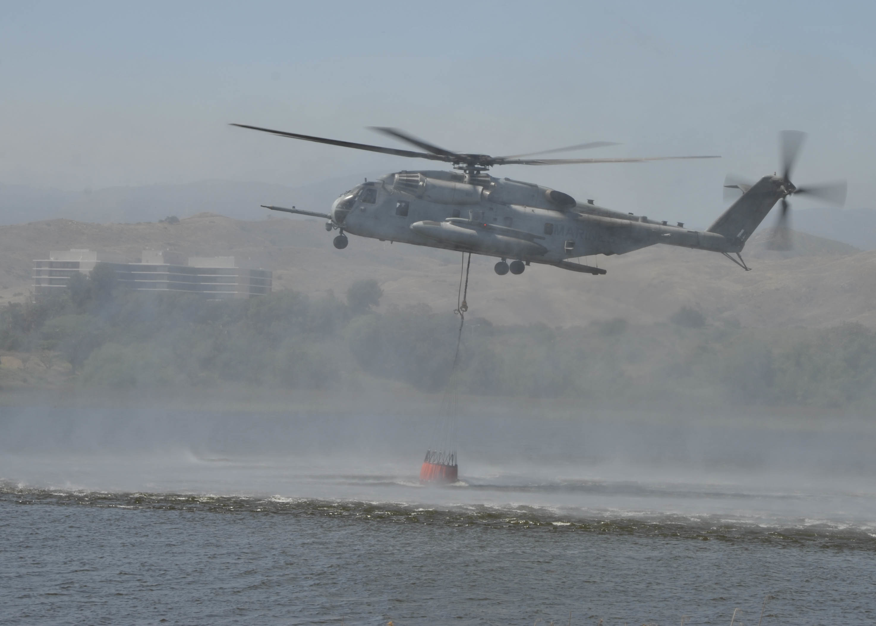 A CH-53E Sea Stallion from the “Flying Tigers” of Heavy Helicopter Squadron 361 pulls water from Lake O’Neill into a 420-gallon suspended bucket during a demonstration at the 2017 Wildland Firefighting Exercise at Lake O’Neill.