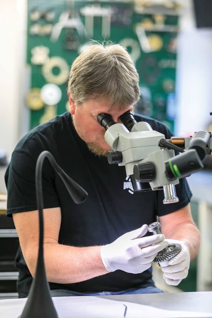 Component shop engineer Jeff Veerman inspects an MD 500 input gear.