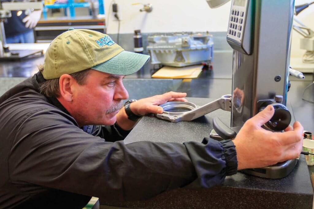Aero-Smith Heli owner Hugh Andrews conducts a conditional inspection on a blade pitch horn.