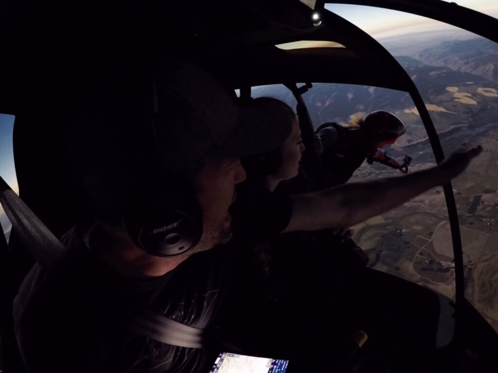 Pilot York Galland, left, and his daughter Margi watch as Chris Farro prepares to jump from Galland's R66 as totality ends and sunlight returns. GoPro media creator Abe Kislevitz is documenting the event from the back seat. Photo courtesy of York Galland / Instagram: @iflyheli