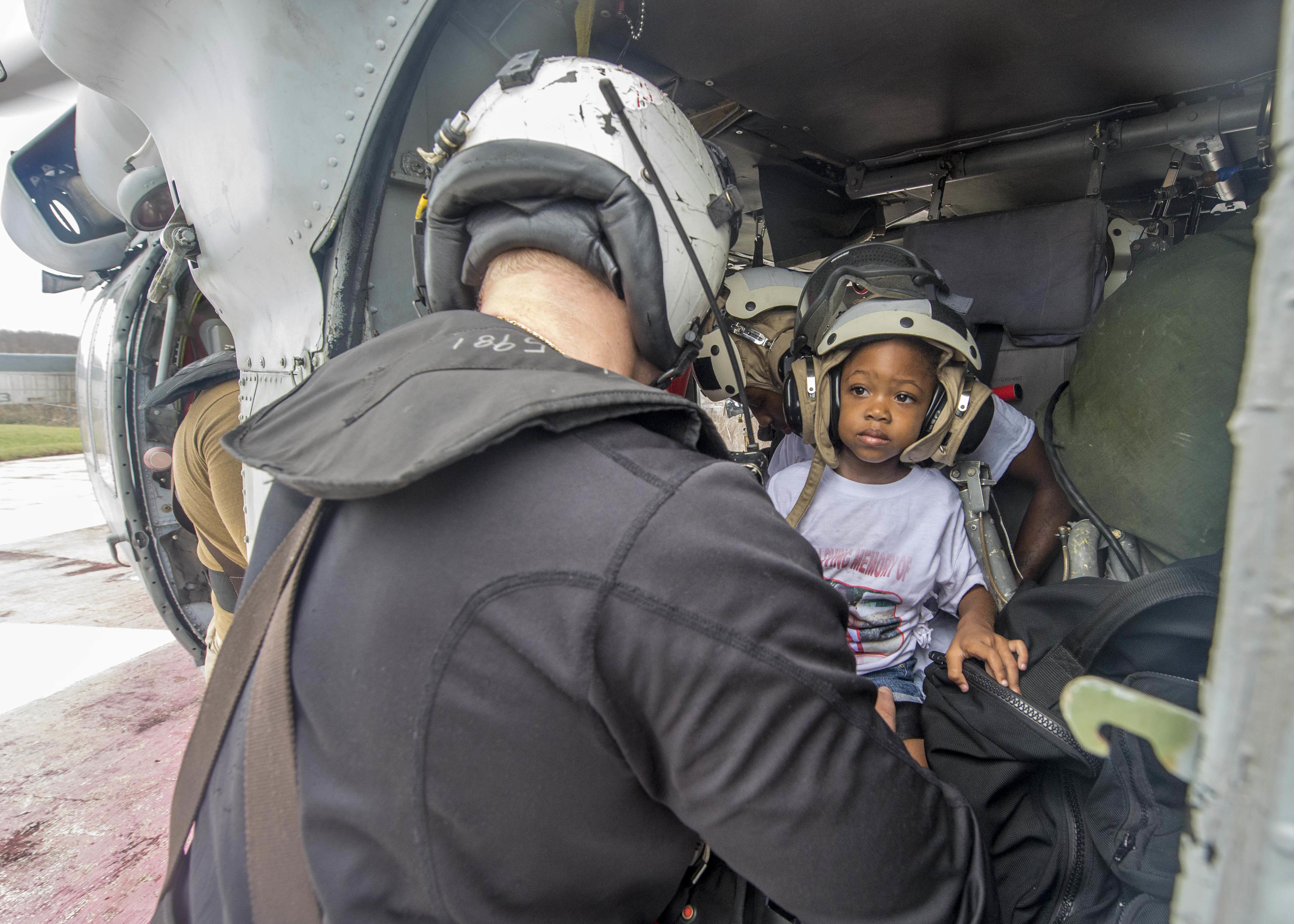Naval Aircrewman (Helicopter) 2nd Class Logan Parkinson, assigned to Helicopter Sea Combat Squadron (HSC) 22, prepares a patient's family for evacuation during relief efforts in the wake of Hurricane Maria in St. Croix, U.S. Virgin Islands, Sept. 21. U.S. Navy MC3 Levingston Lewis Photo