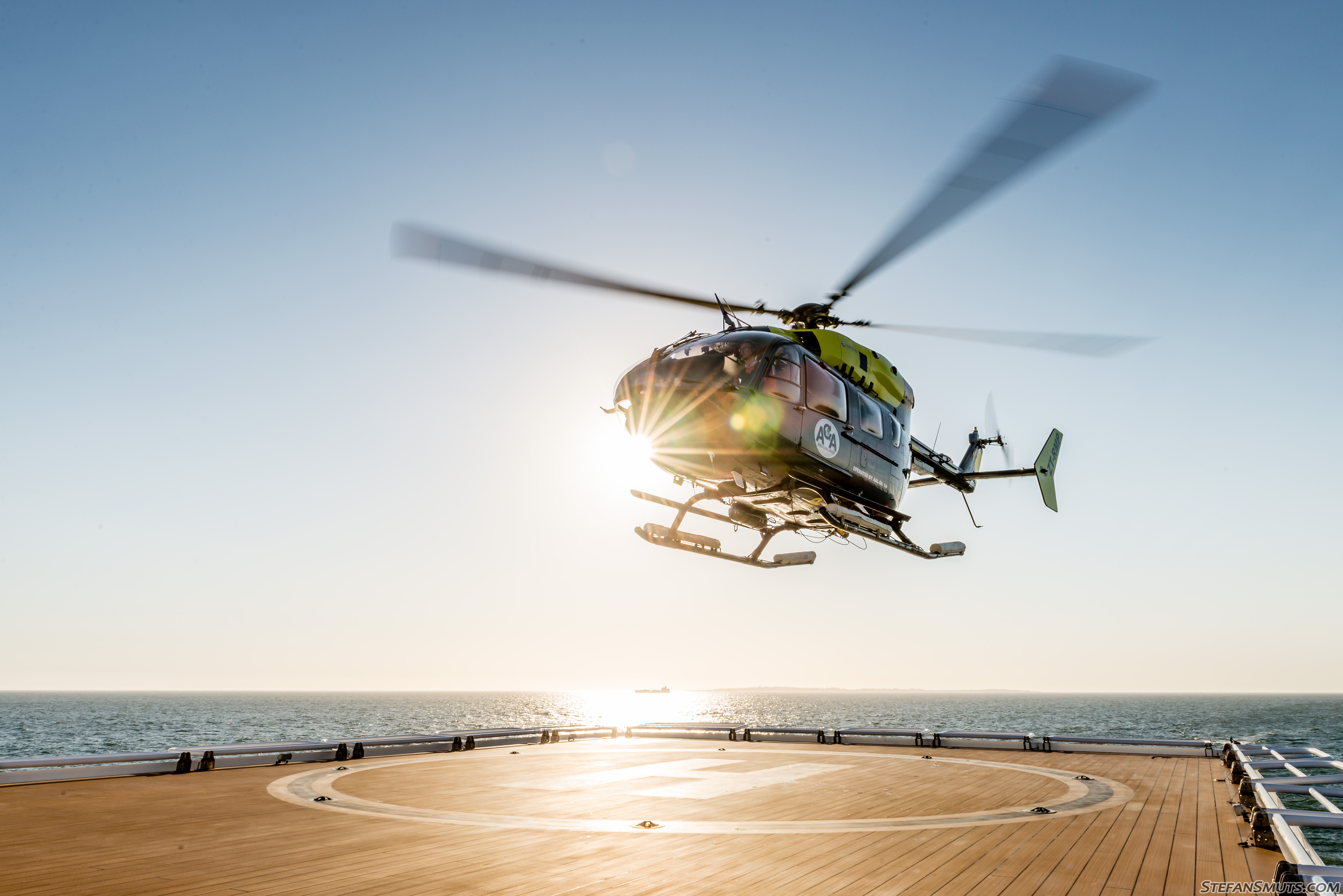 Aerios Global's newest aircraft, the EC145, hovering over a helipad by the water