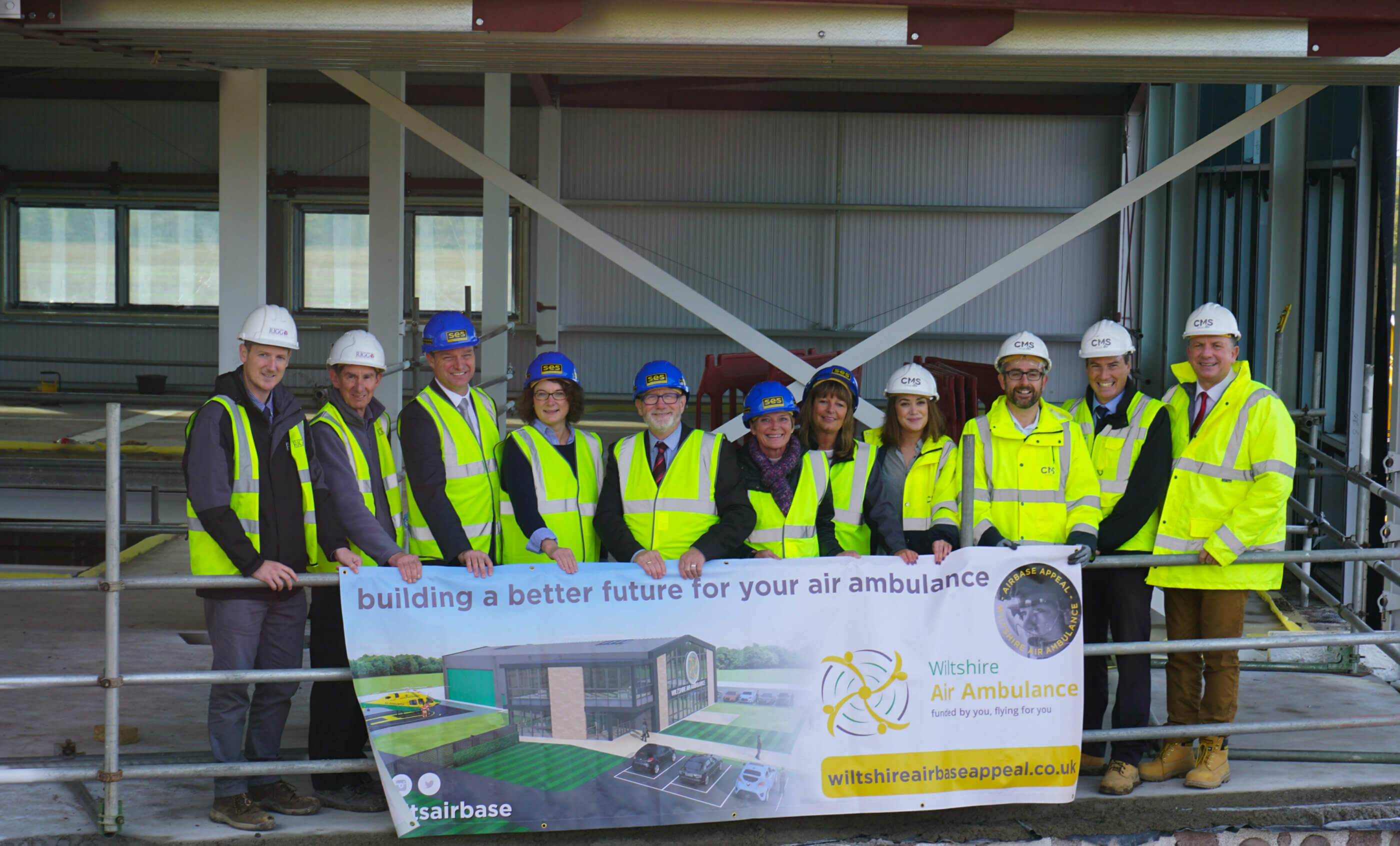Representatives of Wiltshire Air Ambulance, its primary contractor Rigg Construction (Southern) Limited, and its architects and project managers gather inside the new airbase construction site for the topping out ceremony. Wiltshire Air Ambulance Photo