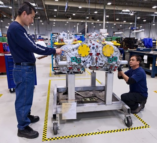 Two Vector technicians work on a helicopter engine. Vector Aerospace Photo