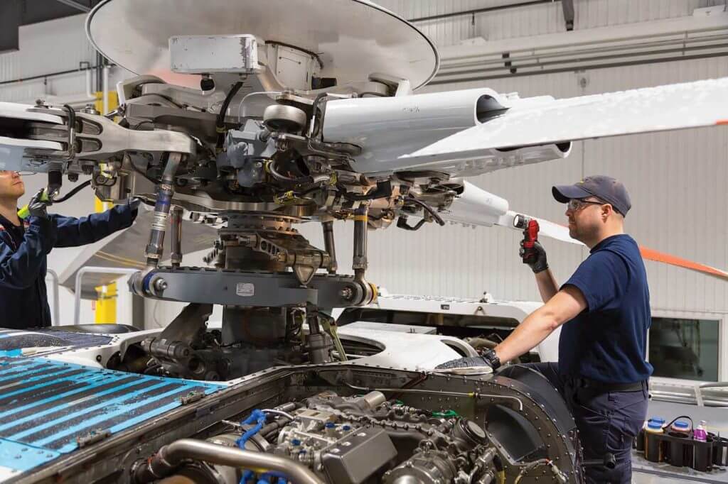 Maintenance engineers inspect the main rotor hub of a Sikorsky S-92. The manufacturer has used HUMS data to extend the part's service life in the past, and is now using that data to predict negative events. Heath Moffatt Photo