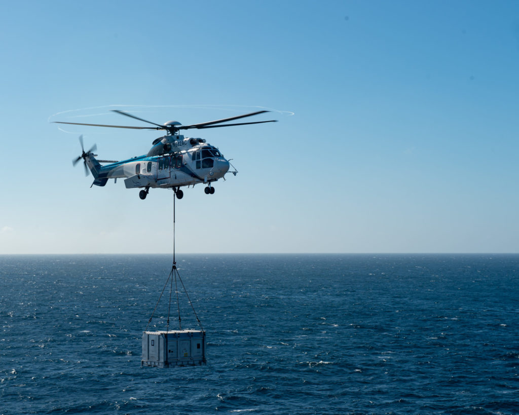 A civilian H225 Super Puma operated by Air Center Helicopters transports a mock F135 engine power module from Lewis and Clark-class dry cargo ship USNS Richard E. Byrd (T-AKE 4) to Nimitz-class nuclear aircraft carrier USS Carl Vinson (CVN 70) during a vertical replenishment-at-sea (VERTREP). 