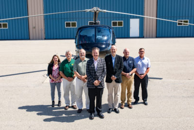 Chuck Surack (center) stands outside the headquarters of Enstrom Helicopter Corp. - the company he dramatically saved from bankruptcy in May. Brent Bundy Photo