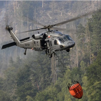 A Sikorsky S-70i Black Hawk in Poland carries an SEI Industries bambi bucket through the forest. From Instagram user aviationspotter_1992