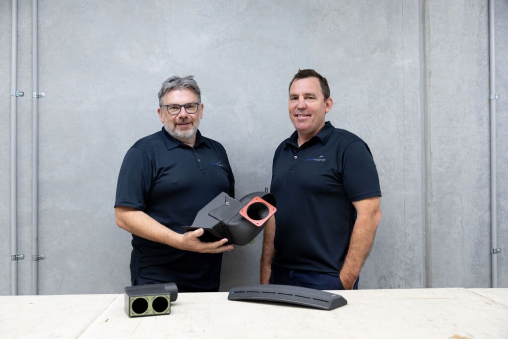 Plane Support Director of Engineering, Jason Hazell, and Director of Manufacturing and Maintenance, Fraser Wright holding 3D printed 214B helicopter parts. Plane Support Photo